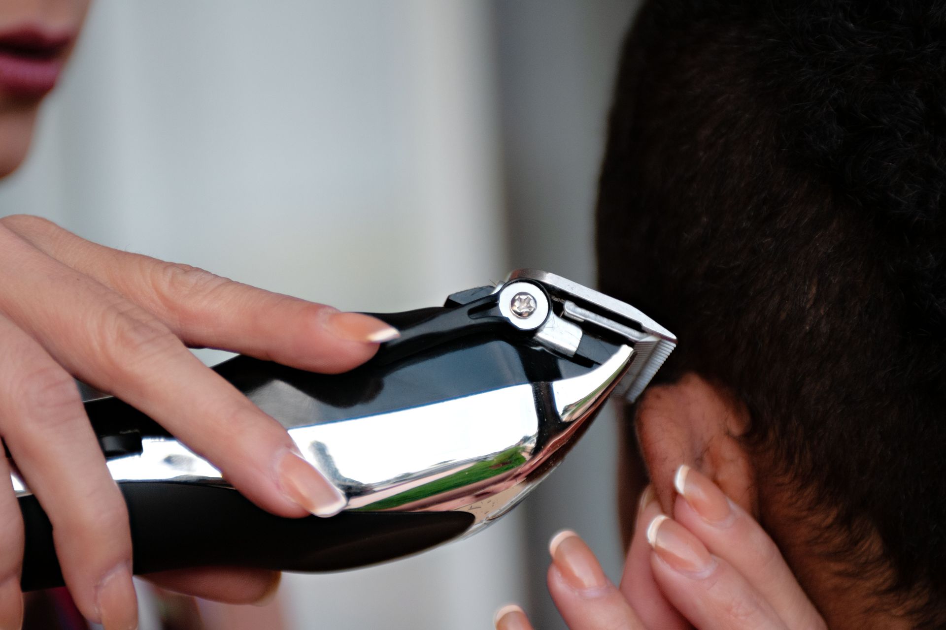 A detailed view of a hair clipper being used to cut hair. Ideal for grooming and barbering concepts.